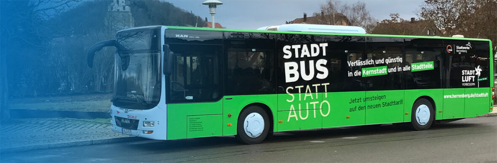 Grüner Omnibus mit Aufschrift Stadt Bus statt Auto