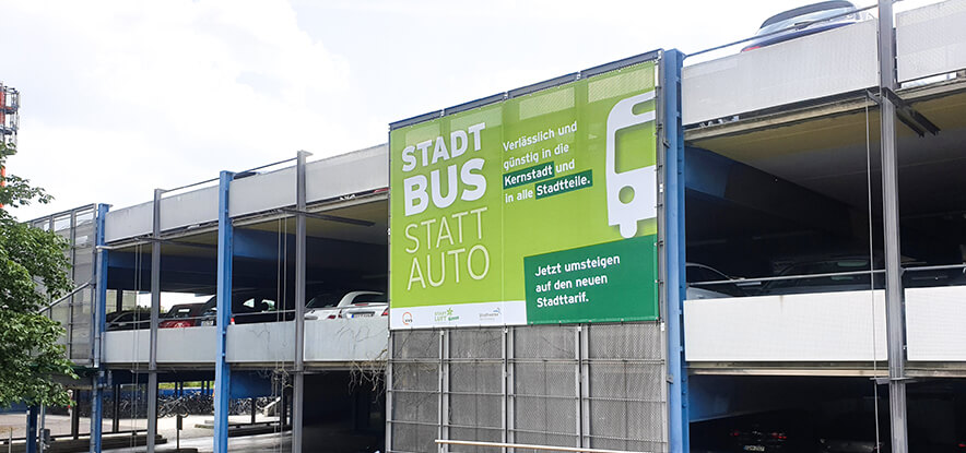 Parkhaus mit Parkdecks und Plakatwerbung Stadt Bus statt Auto